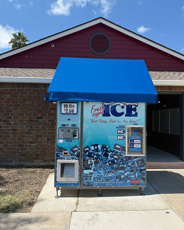 On-site ice vending machine with blue awning and pricing displayed