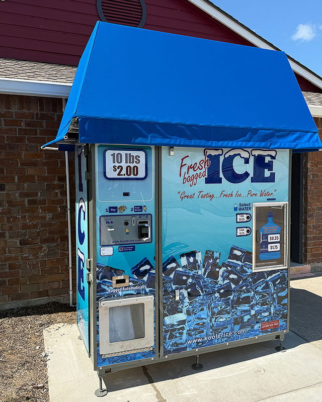 Angled view of the on-site ice vending machine showing the front and side