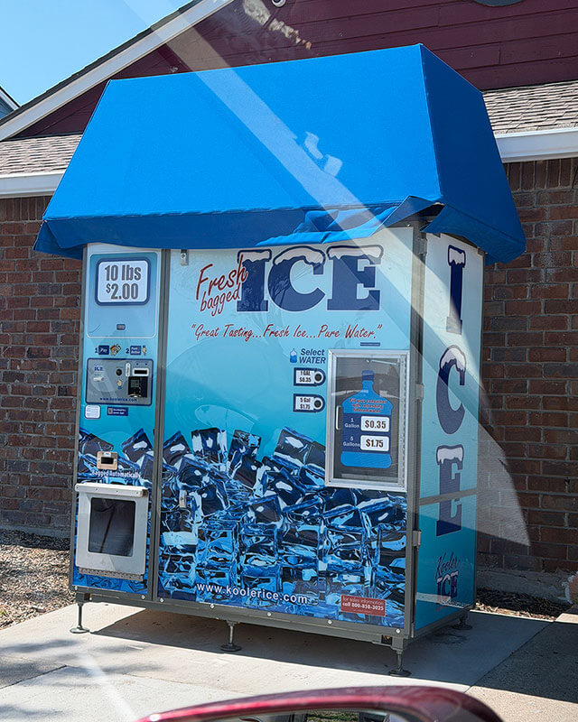 Ice vending machine showing pricing and payment controls from an angled view